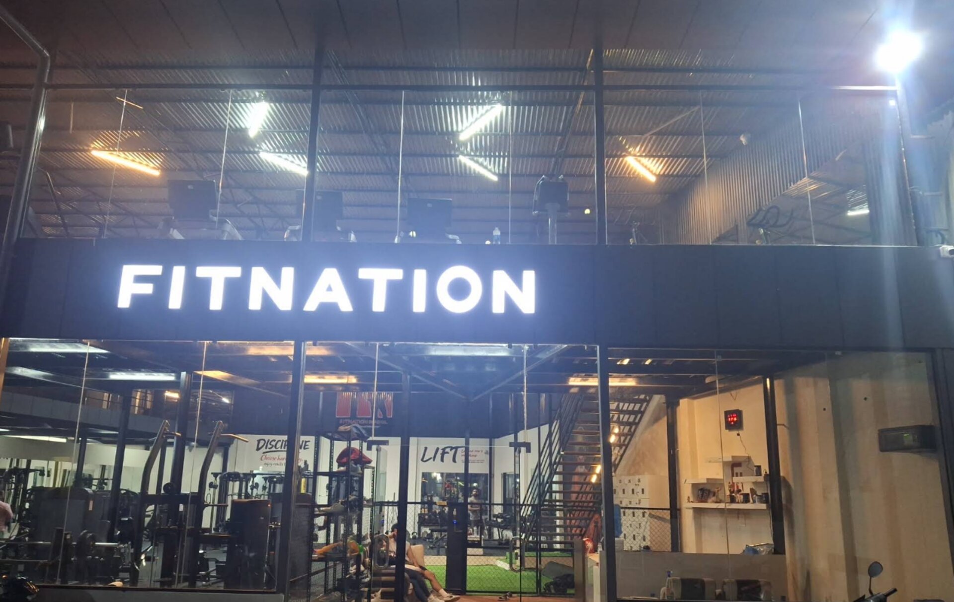 FitNation Nepal — flagship gym storefront at night, glowing FITNATION sign